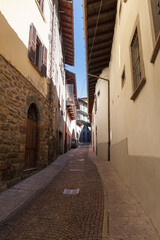 Obraz premium Street view of historical village Gromo, Bergamo, Lombardy, Italy. Narrow cobbled streets. Sun lights and shadows.