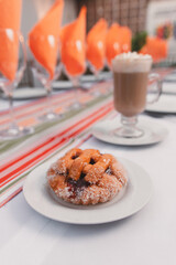 Close-up view of a small pastafrola served on a plate with coffee in the background.
