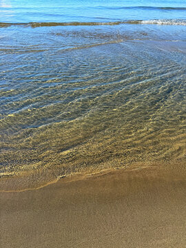 Sea gentle waves on sand beach