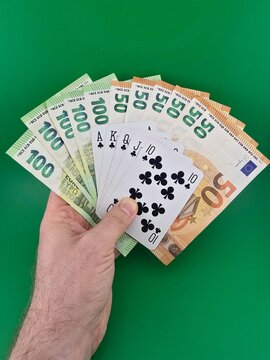 Playing cards and money on a green background.