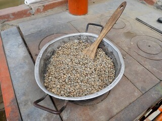 Roasting coffee beans on traditional stove at organic coffee plantation in Salento, Colombia.