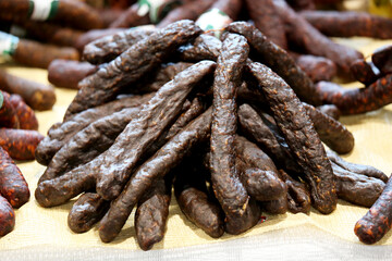Close up composition of traditional hungarian homemade specialty foods, salami sausage etc. on farmers market for sale. Pile of delicious regional homemade products in row