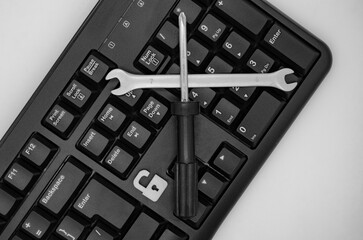 screwdriver and wrench on computer keyboard