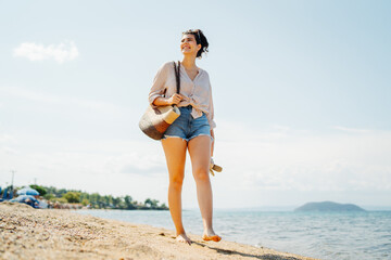 Young caucasian woman is going to the beach with straw bag	