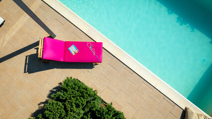 Pool side furniture with magenta sun bed