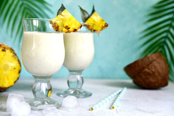 Traditional caribbean cocktail pina colada with ingredients for making : cream, pineapple, coconut...