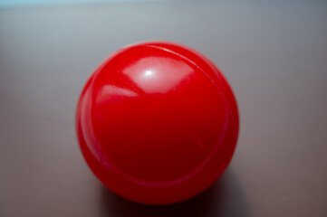 Red ball on a blurred gray background.