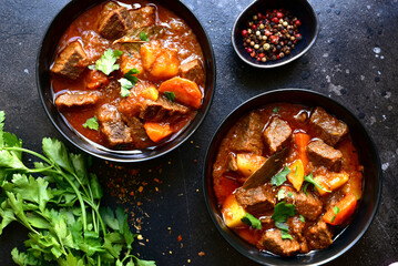 Goulash (meat stew with tomatoes and paprika) - traditional dish of hungarian cuisine.Top view with copy space.