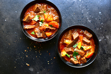 Goulash (meat stew with tomatoes and paprika) - traditional dish of hungarian cuisine.Top view with...