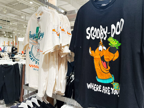 Lviv, Ukraine - February 13, 2025: Display of cartoon-themed t-shirts hanging on racks in a clothing store