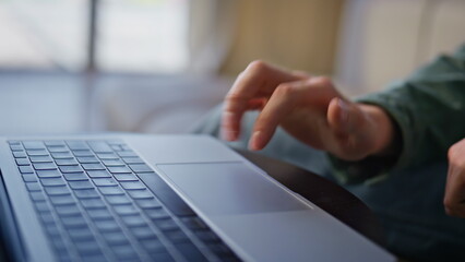 Man hands using laptop touchpad in cabinet. Closeup unknown person working alone