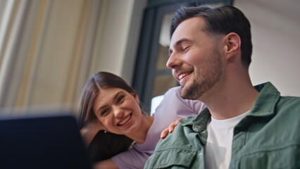 Cheerful boyfriend working laptop girlfriend leaning closeup. Lovers having fun