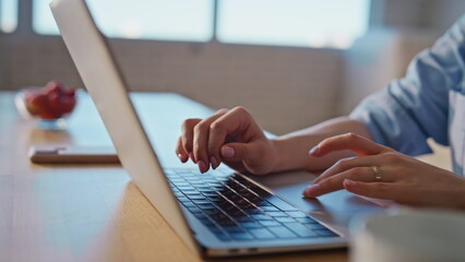 Hands pressing laptop keyboard on home at morning closeup. Woman typing computer