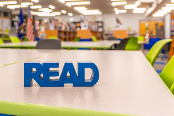 Empty school library with blue block read sign on work table.	