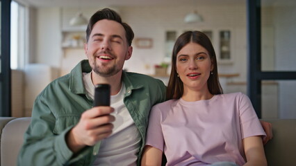 Relaxed friends watching movie switching channels during home weekend closeup