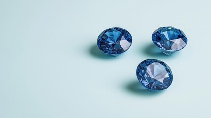 Three Sparkling Blue Gemstones On Light Blue Background