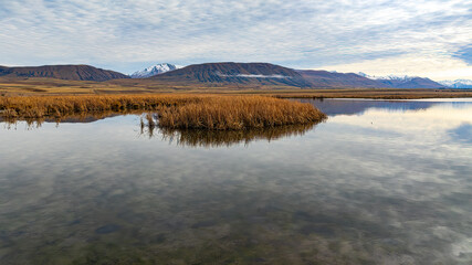 Drone  view of the Ashburton highlands with a river and lake in the dry arid terrain on the way to Lake Heron
