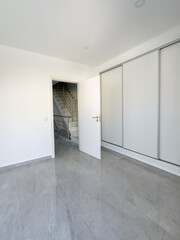 Bright and spacious interior featuring polished gray tiled flooring and sleek contemporary design.