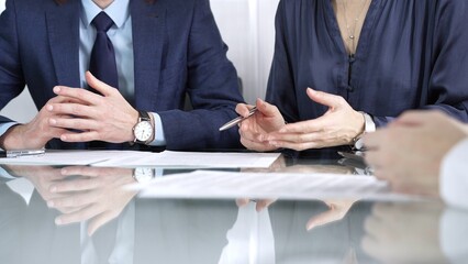 Business partners or lawyers are discussing contract papers during a meeting, negotiating and making decisions together. Business people concept, close up