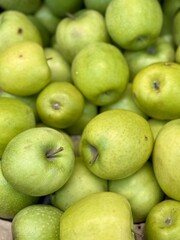 Box filled with fresh natural bio organic green apples placed on counter in local food market. Close-up