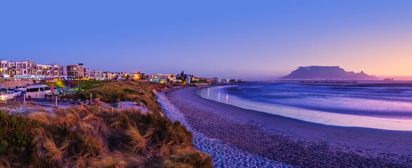 Fototapeta premium Panorama of Big Bay and Table Mountain During Twilight with Colorful Sky and Reflection, Bloubergstrand, South Africa