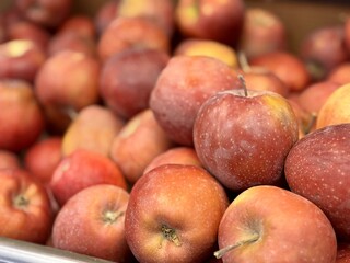 Box filled with fresh natural bio organic red apples placed on counter in local food market