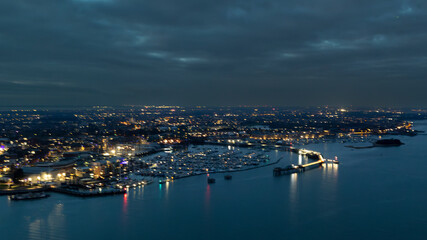 Obraz premium Night time city scape with harbour lights.