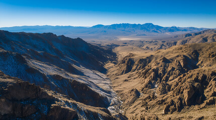Aerial view of rugged mountain pass with dramatic light and shadow interplay