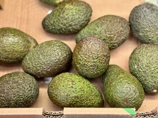 Large rifle green avocados harvested ready to eat are sold on supermarket shelves top view. Healthy eating. Close-up