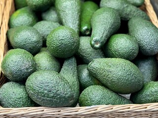 Large rifle green avocados harvested ready to eat are sold on supermarket shelves top view. Healthy eating. Close-up