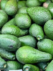 Large rifle green avocados harvested ready to eat are sold on supermarket shelves top view. Healthy eating. Close-up