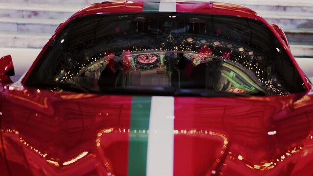 Close up of a red car with the Italian flag on it in the courtyard of the Monte Carlo Casino in the evening in Monaco