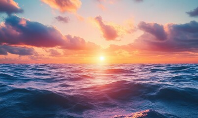 The sky above a sprawling, rolling ocean is painted with vibrant colors by the sunset, with the setting sun bathing the water in a warm glow.