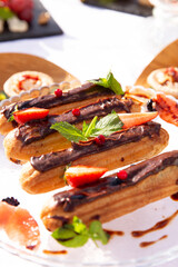 Eclairs in a plate on the table.
