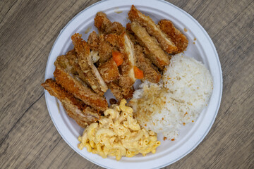 Take-out order of crispy katsu chicken served with rice and macaroni salad on a paper plate