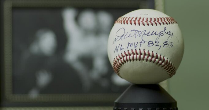 Fake Dale Murphy autograph on baseball near out of focus photo - closeup