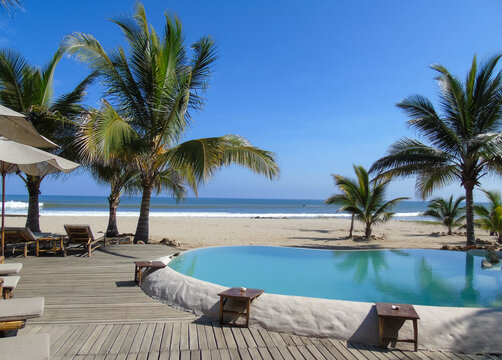 Beach resort in Tumbes (north of Peru) with palm trees, swimming pool and view of the Pacific Ocean.