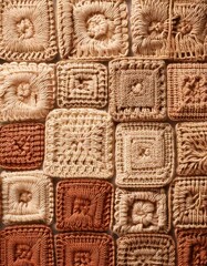 Fototapeta premium Crochet squares in warm tones showcase intricate handmade designs and textures