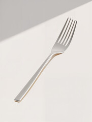 Elegant silver fork resting on a minimalistic surface in soft natural light