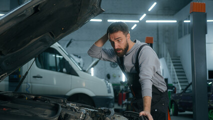 Caucasian man professional auto mechanic technician car service worker opening automobile hood looking under bonnet shocked male confused problem vehicle breakdown broken transport in garage station