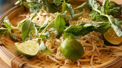 Woman selects toppings for pho from tray filled with fresh sprouts herbs and lime Traditional Vietnamese preparation highlighting beans freshness vibrant flavors Beans enhances taste pho experience