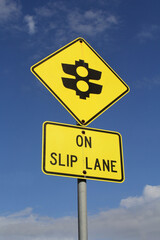 Yellow Traffic Lights On Slip Lane sign against a blue sky background
