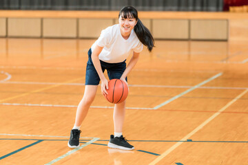 体育館でバスケットをする体操着姿の女子中学生・女子高生
