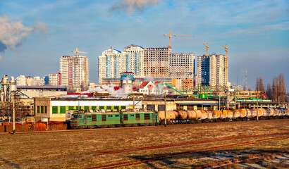 Old Soviet electric locomotive with an oil tanker train at Darnytsia station in Kyiv, the capital of Ukraine