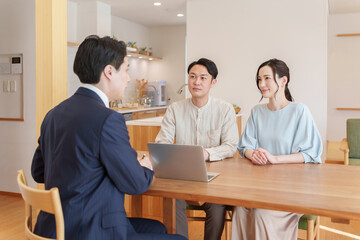 話す不動産営業マンと客夫婦