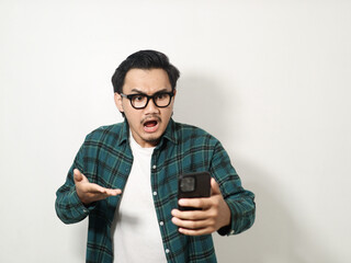 A man shows an angry expression while looking at his cell phone isolated on white background