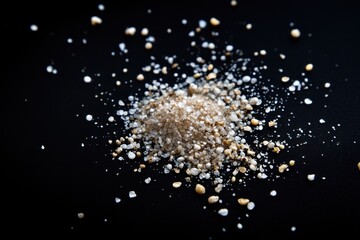 Small pile of light colored grains on a dark surface