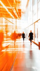 Modern interior of an office building, with glass walls in an orange hue and blurred people walking in motion blur