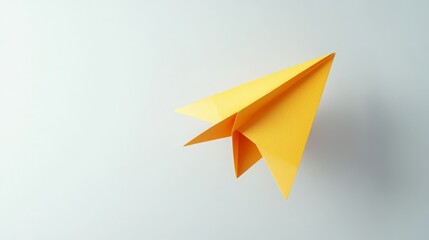 Bright yellow paper airplane in flight against a light gray background.