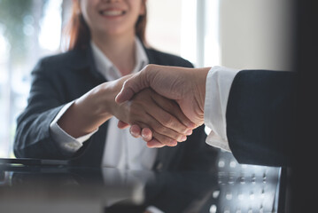 Business handshake. Business people making a handshake, close up. Two corporate businessman shaking hands during meeting in office